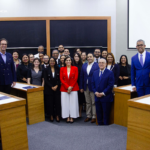 Grupo de personas de pie de distintos generos dentro de un aula